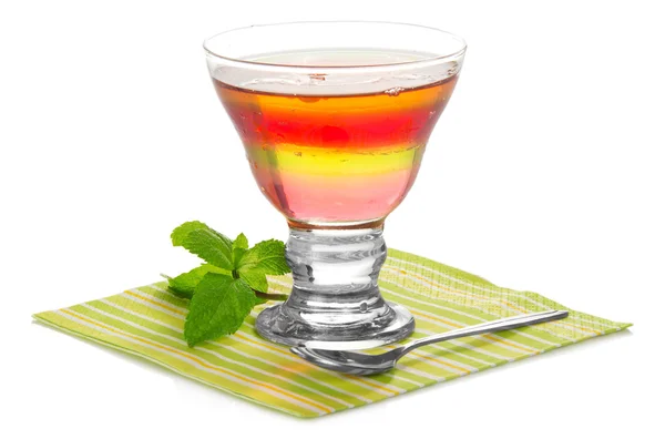 Glas mit Fruchtgelee, einem Löffel und einem Minzblatt auf der gestreiften Serviette, isoliert auf weiß — Stockfoto