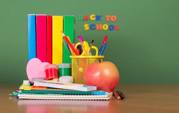 De vuelta a la escuela. Los libros de texto y el juego de los accesorios escolares sobre la mesa — Foto de Stock