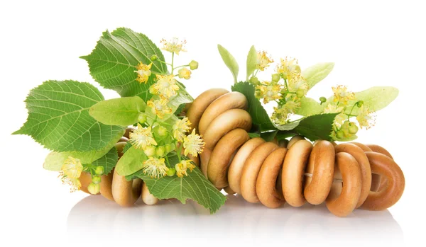 The bagels connected by a rope, and linden flowers, isolated on white — Stock Photo, Image