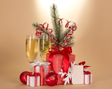 Şampanya, tinsel, hediye kutuları, oyuncaklar ve arka plan bej boş kart köknar ağacı dalı