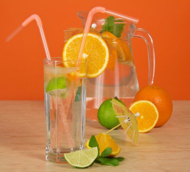 sürahi, saman, bir limon ve bir tablo üzerinde bir şemsiye ile içki cam