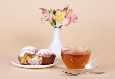 iştah açıcı cupcakes, çay, bej renkli bir arka planda bir Vazoda Çiçekler