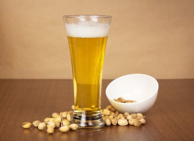 bira ve kağıt karşı bir kase dışına düşmüş fıstık ile cam