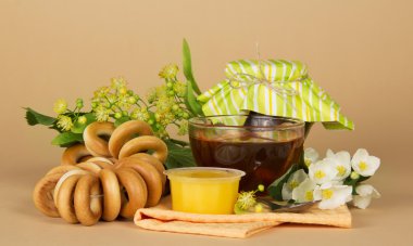 fincan çay, bal, reçel banka, simit, çiçekler ve bej bir peçeteye bir bağlama