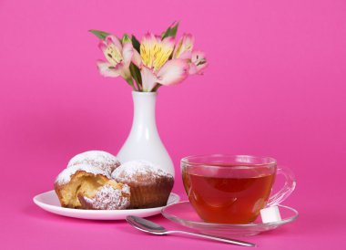 fincan çay, bir kaşık ve pembe bir tabak üzerinde cupcakes