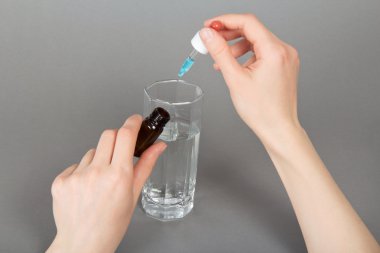 bir bardak su ile tıbbi damla damlaması el,