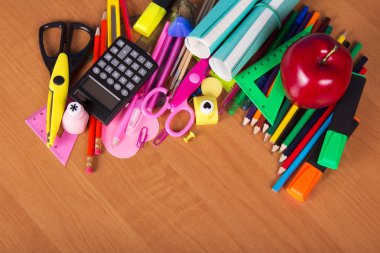 parlak office araçlar kümesi, bir egzersiz kitabı ve bir masada elma