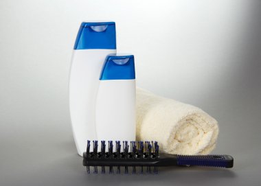 curtailed havlu bir saç fırçası ve kozmetik bir duş almak için gri bir arka plan ayarla