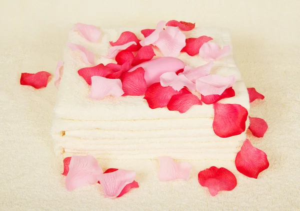 Serviettes et savon sous pétales de roses sur un chiffon éponge — Photo