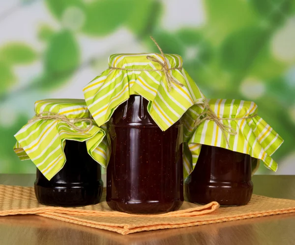 Drie potten van jam en servetten op een tafel — Stockfoto