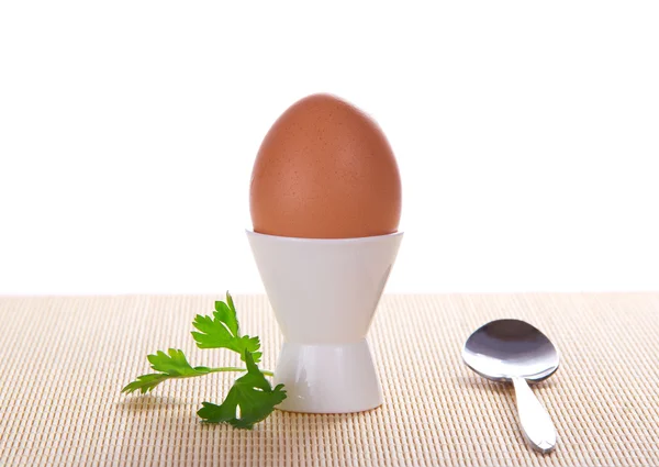 Gekochtes Ei in einem Behälter und einem Löffel auf dem Bambustuch, isoliert auf weißem — Stockfoto