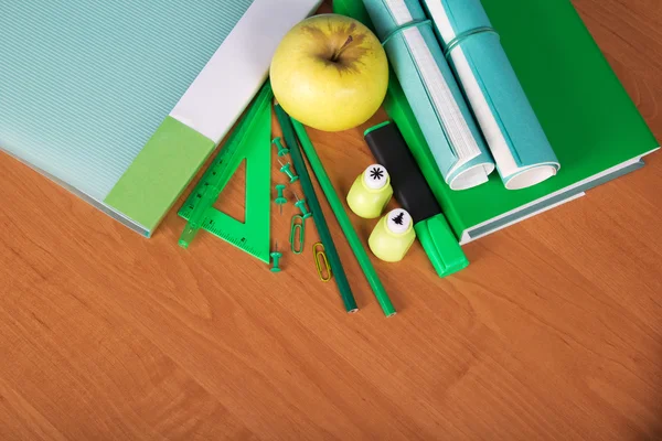 Das Buch, die Mappe, Schulhefte, ein Satz Bürogeräte und ein Apfel auf dem Tisch — Stockfoto