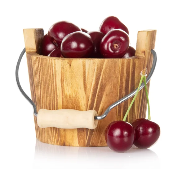 Wooden bucket with red ripe sweet cherry and some berries near — Stock Photo, Image