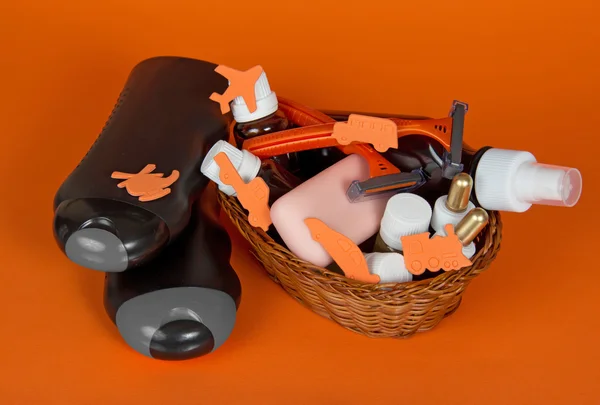 Gel douche, shampooing et un grand ensemble de cosmétiques, dans un panier ondulé, sur un fond orange — Photo