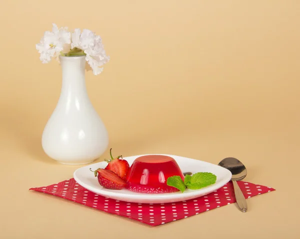 Placa con gelatina de fresa, cuchara, servilleta y jarrón con las flores —  Fotos de Stock