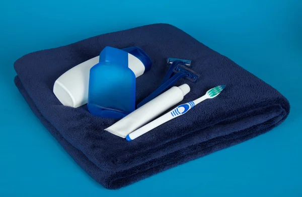 Rasoir de sécurité, lotion, serviette et set pour le soin d'une bouche, sur fond bleu — Photo