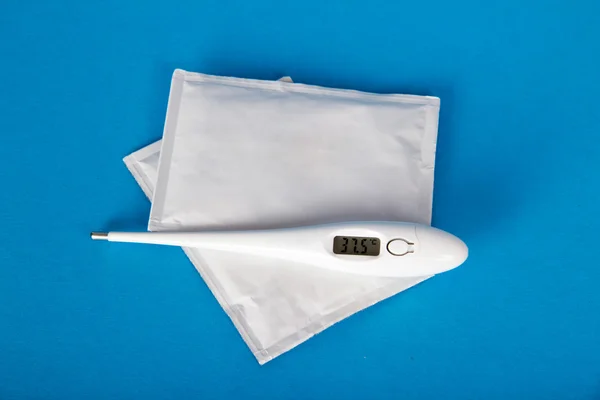 The thermometer and febrifugal powders on a blue background — Stock Photo, Image