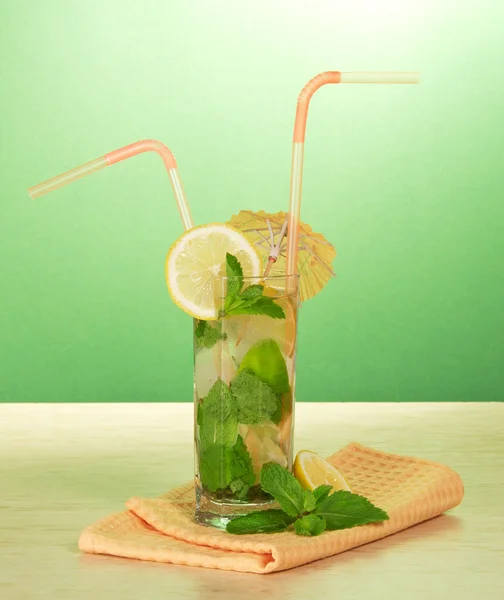 Mojito, cocktail straws, a lemon, mint, a napkin on a table — Stock Photo, Image