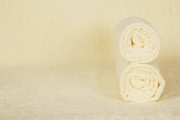 Two fluffy towels a roll against a terry cloth — Stock Photo, Image