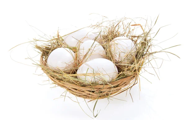 Eggs, hay in a bast basket, isolated on white — Stock Photo, Image