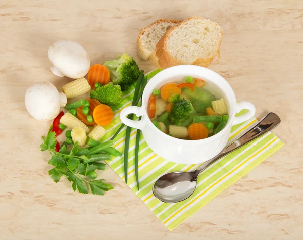 Legumes frescos, cogumelos, pão e xícara de sopa em um guardanapo listrado — Fotografia de Stock