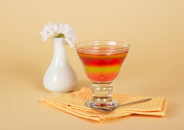 Vaas met bloemen, glas met gelei en een lepel op een servet — Stockfoto