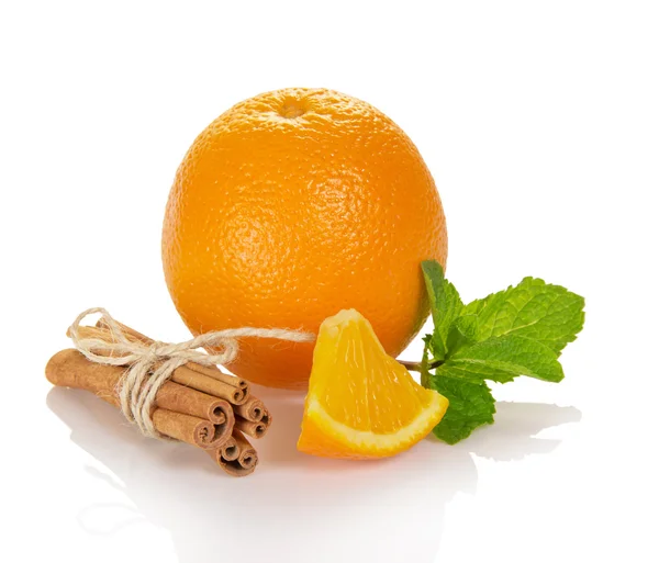 Leuchtend reife Orange, die miteinander verbundenen Zimt- und Minzstäbchen — Stockfoto