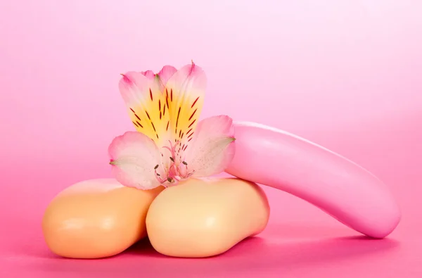 Tumpukan sabun toilet dan bunga dari alstroemeria pada latar belakang merah muda — Stok Foto