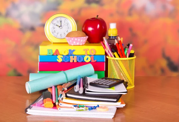 A set of school accessories, a alarm clock, a cake, apple and drink on a table — Stock Photo, Image