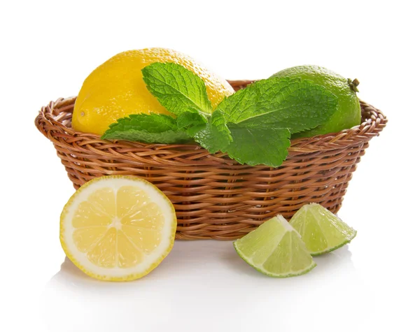 Lemon, lime and mint in a basket, slices of fruit near a basket — Stock Photo, Image