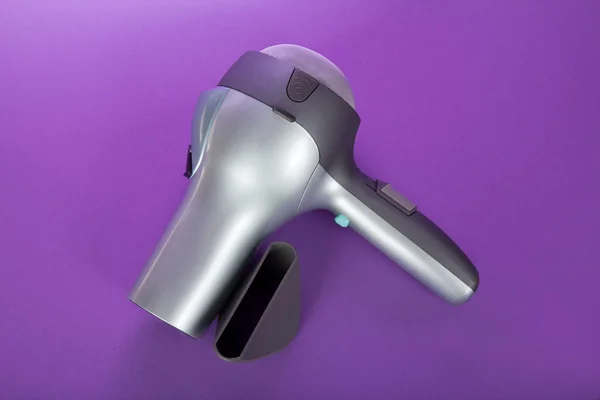 The hair dryer for drying of hair and additional accessories, on the violet — Stock Photo, Image