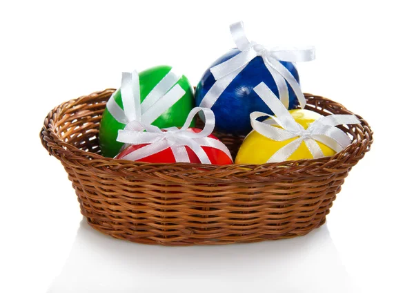 The Easter eggs decorated with ribbons, in the wattled vase, isolated on white — Stock Photo, Image