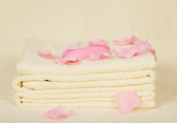 Towels and soap under petals of roses on a terry cloth — Stock Photo, Image