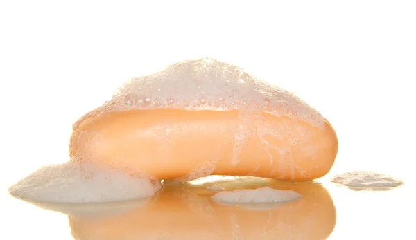 Piece of soap of orange color with foam on a beige background — Stock Photo, Image