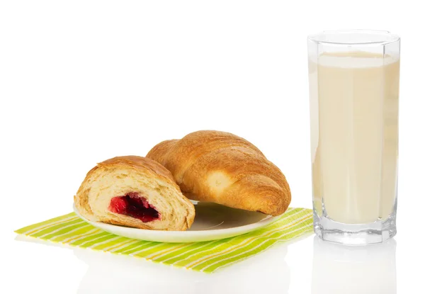 Verse croissants met jam op een servet en de melkglas, geïsoleerd op wit — Stockfoto