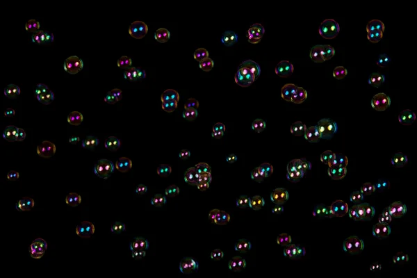 Las burbujas de jabón transparentes e iridiscentes aisladas en negro —  Fotos de Stock