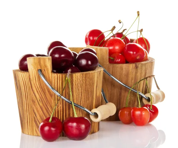 Olika kvaliteter av sötkörsbär i trä hinkar och några bär nära — Stockfoto