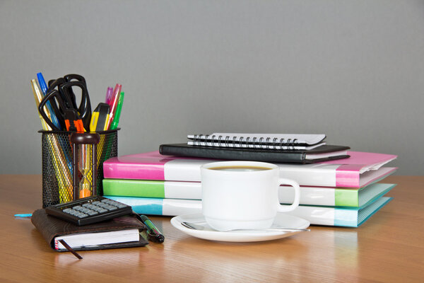Folders for documents a office supply in a support hourglasses and a cup of coffee on a table