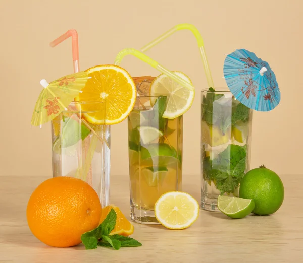 Cocktail with a straw and an umbrella, drink with an orange slice, tea with a lemon — Stock Photo, Image