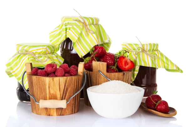 Jars of jam, buckets with berries, a cup with sugar and strawberry in the wooden spoon — Stock Photo, Image