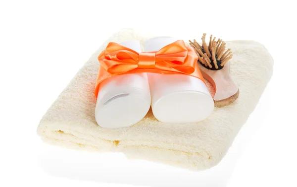Ensemble de cosmétiques avec un arc lumineux et une brosse à cheveux en bois sur une serviette, isolé sur blanc — Photo
