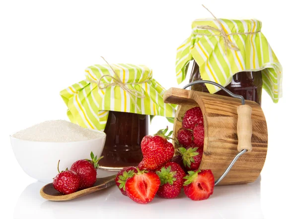 Pots de confiture, une tasse de sucre, cuillère en bois avec des baies et une colline de fraise — Photo