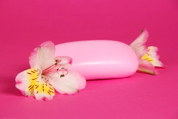 Jabón de tocador rosa y la flor de la alstroemeria sobre un fondo rosa —  Fotos de Stock