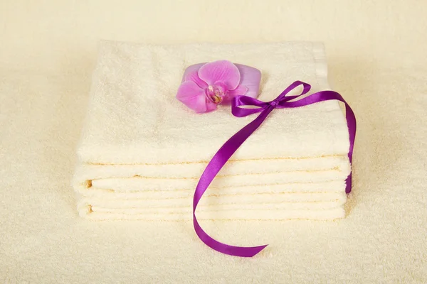 The bathing accessories decorated with a flower of an orchid and a tape on a terry cloth — Stock Photo, Image