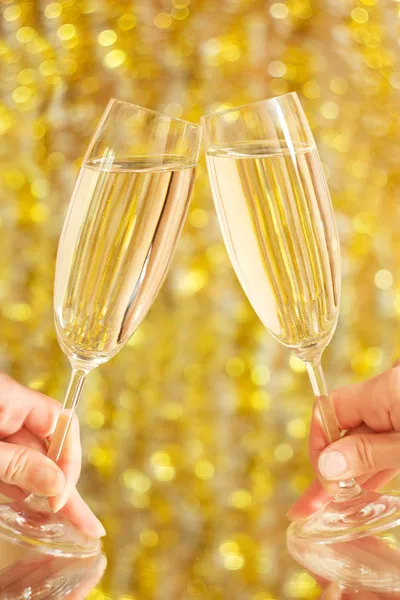 Bardak şampanya ellerini, bulanık arka planda — Stok fotoğraf
