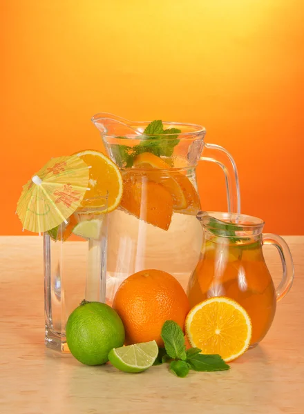 Kannor med drink och te, ett glas med ett paraply och en citrus — Stockfoto