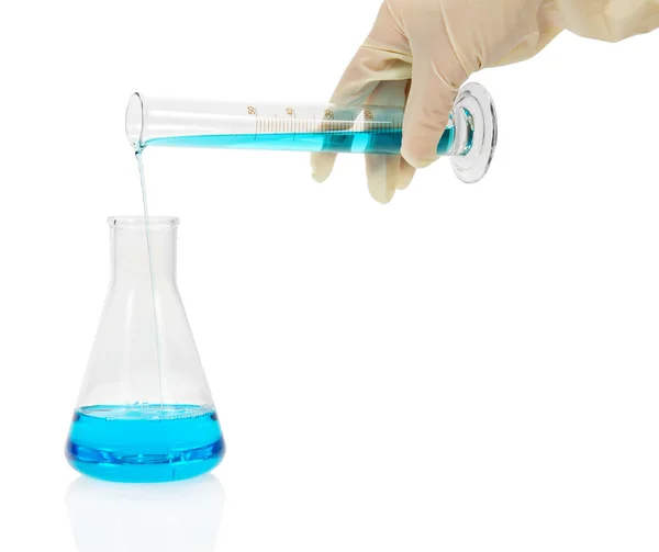 The flask with blue liquid, a hand holds a measured tube isolated on white — Stock Photo, Image