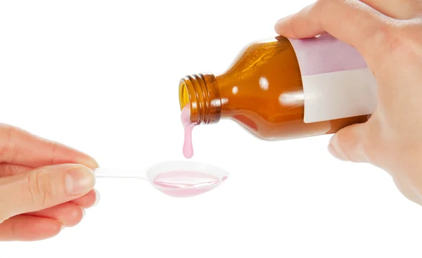 Händer Häll rosa medicin i en sked — Stockfoto
