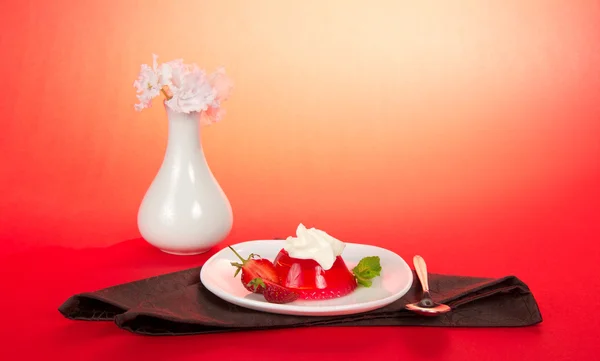 Placa con gelatina y crema batida, una cuchara y una servilleta marrón en el rosa —  Fotos de Stock