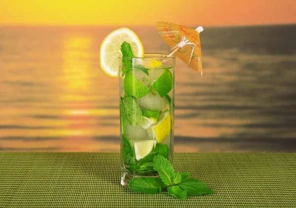 Mojito, è decorato con un ombrello e una fetta di limone e menta su un bambù verde — Foto Stock